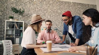 A small startup team works together around a table
